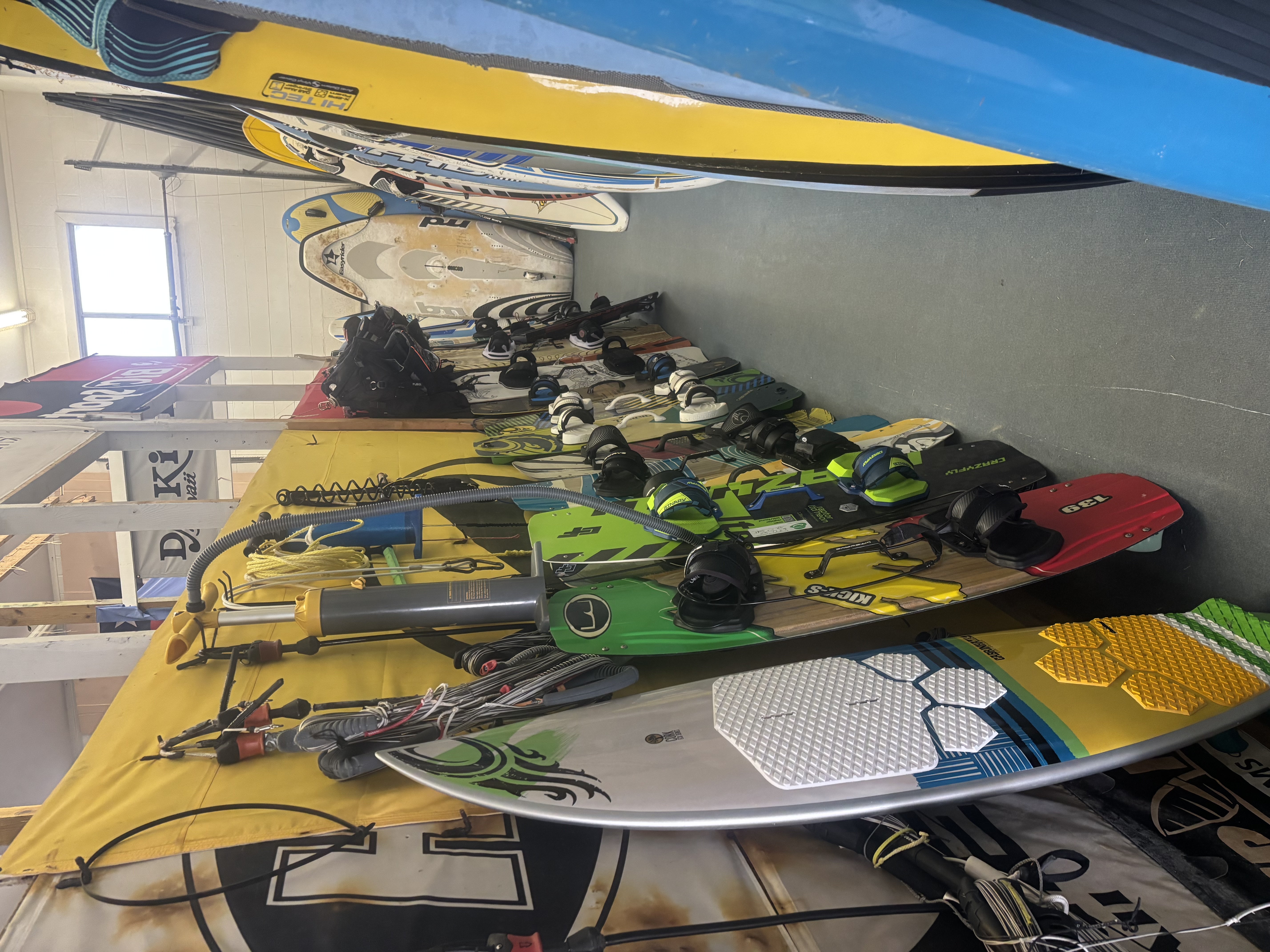 room filled with various surfboards and equipment, showcasing a vibrant collection for surfing enthusiasts.